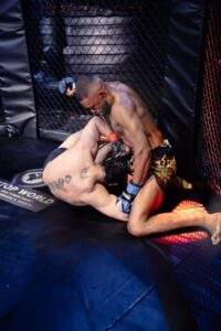 Two MMA fighters grappling against the cage during a Fight Island Championship match in Mallorca