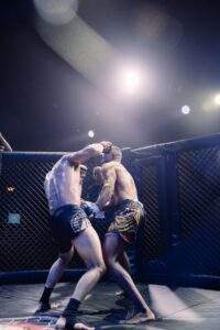 Two MMA fighters grappling against the cage during a Fight Island Championship match in Mallorca