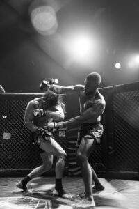 Two MMA fighters grappling against the cage during a Fight Island Championship match in Mallorca