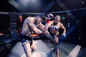 Two MMA fighters grappling against the cage during a Fight Island Championship match in Mallorca