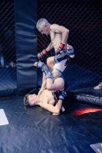 Two MMA fighters grappling against the cage during a Fight Island Championship match in Mallorca