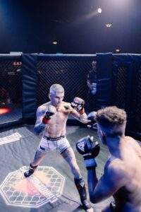 Two MMA fighters grappling against the cage during a Fight Island Championship match in Mallorca