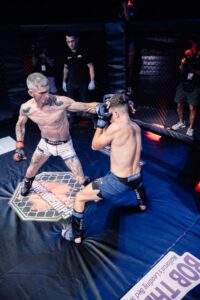 Two MMA fighters grappling against the cage during a Fight Island Championship match in Mallorca