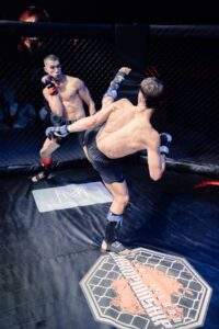 Two MMA fighters grappling against the cage during a Fight Island Championship match in Mallorca