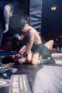 Two MMA fighters grappling against the cage during a Fight Island Championship match in Mallorca