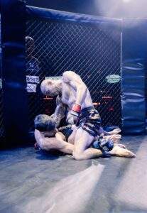 Two MMA fighters grappling against the cage during a Fight Island Championship match in Mallorca