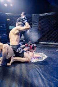 Two MMA fighters grappling against the cage during a Fight Island Championship match in Mallorca