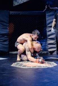 Two MMA fighters grappling against the cage during a Fight Island Championship match in Mallorca
