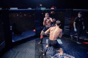 Two MMA fighters grappling against the cage during a Fight Island Championship match in Mallorca