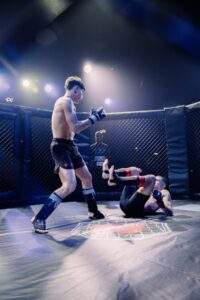 Two MMA fighters grappling against the cage during a Fight Island Championship match in Mallorca