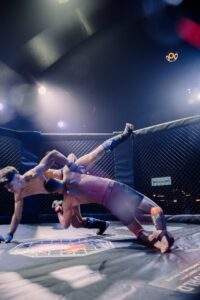 Two MMA fighters grappling against the cage during a Fight Island Championship match in Mallorca