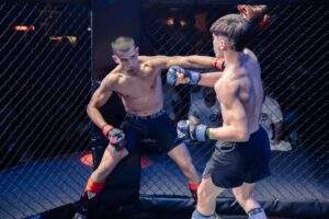 Two MMA fighters grappling against the cage during a Fight Island Championship match in Mallorca