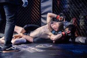 Two MMA fighters grappling against the cage during a Fight Island Championship match in Mallorca