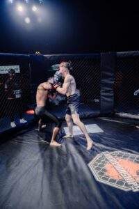 Two MMA fighters grappling against the cage during a Fight Island Championship match in Mallorca