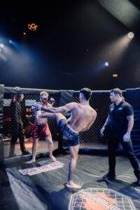 Two MMA fighters grappling against the cage during a Fight Island Championship match in Mallorca