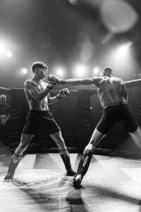 Two MMA fighters grappling against the cage during a Fight Island Championship match in Mallorca