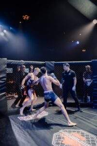Two MMA fighters grappling against the cage during a Fight Island Championship match in Mallorca