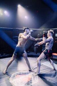 Two MMA fighters grappling against the cage during a Fight Island Championship match in Mallorca