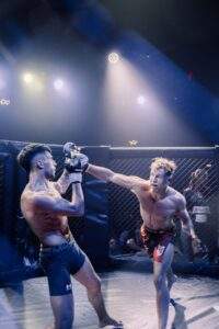 Two MMA fighters grappling against the cage during a Fight Island Championship match in Mallorca