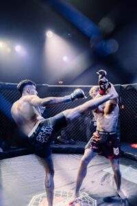 Two MMA fighters grappling against the cage during a Fight Island Championship match in Mallorca