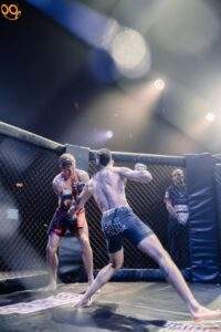 Two MMA fighters grappling against the cage during a Fight Island Championship match in Mallorca