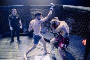 Two MMA fighters grappling against the cage during a Fight Island Championship match in Mallorca