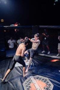 Two MMA fighters grappling against the cage during a Fight Island Championship match in Mallorca