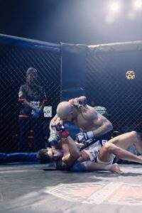 Two MMA fighters grappling against the cage during a Fight Island Championship match in Mallorca
