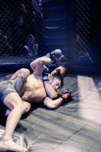 Two MMA fighters grappling against the cage during a Fight Island Championship match in Mallorca