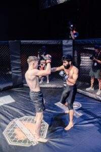 Two MMA fighters grappling against the cage during a Fight Island Championship match in Mallorca