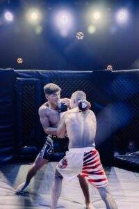 Two MMA fighters grappling against the cage during a Fight Island Championship match in Mallorca