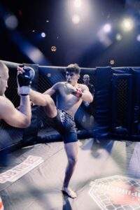 Two MMA fighters grappling against the cage during a Fight Island Championship match in Mallorca