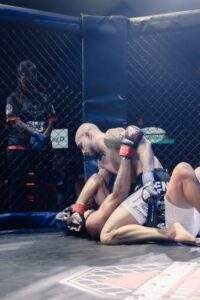 Two MMA fighters grappling against the cage during a Fight Island Championship match in Mallorca
