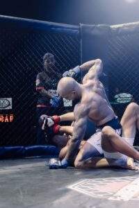 Two MMA fighters grappling against the cage during a Fight Island Championship match in Mallorca